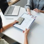 A woman submitting a residency application form