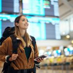 A woman excited to travel with her passport in the airport