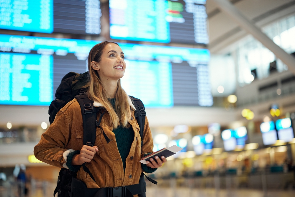 A woman excited to travel with her passport in the airport