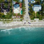 An aerial view of beachside mansions in one of the cities with the most millionaires worldwide.